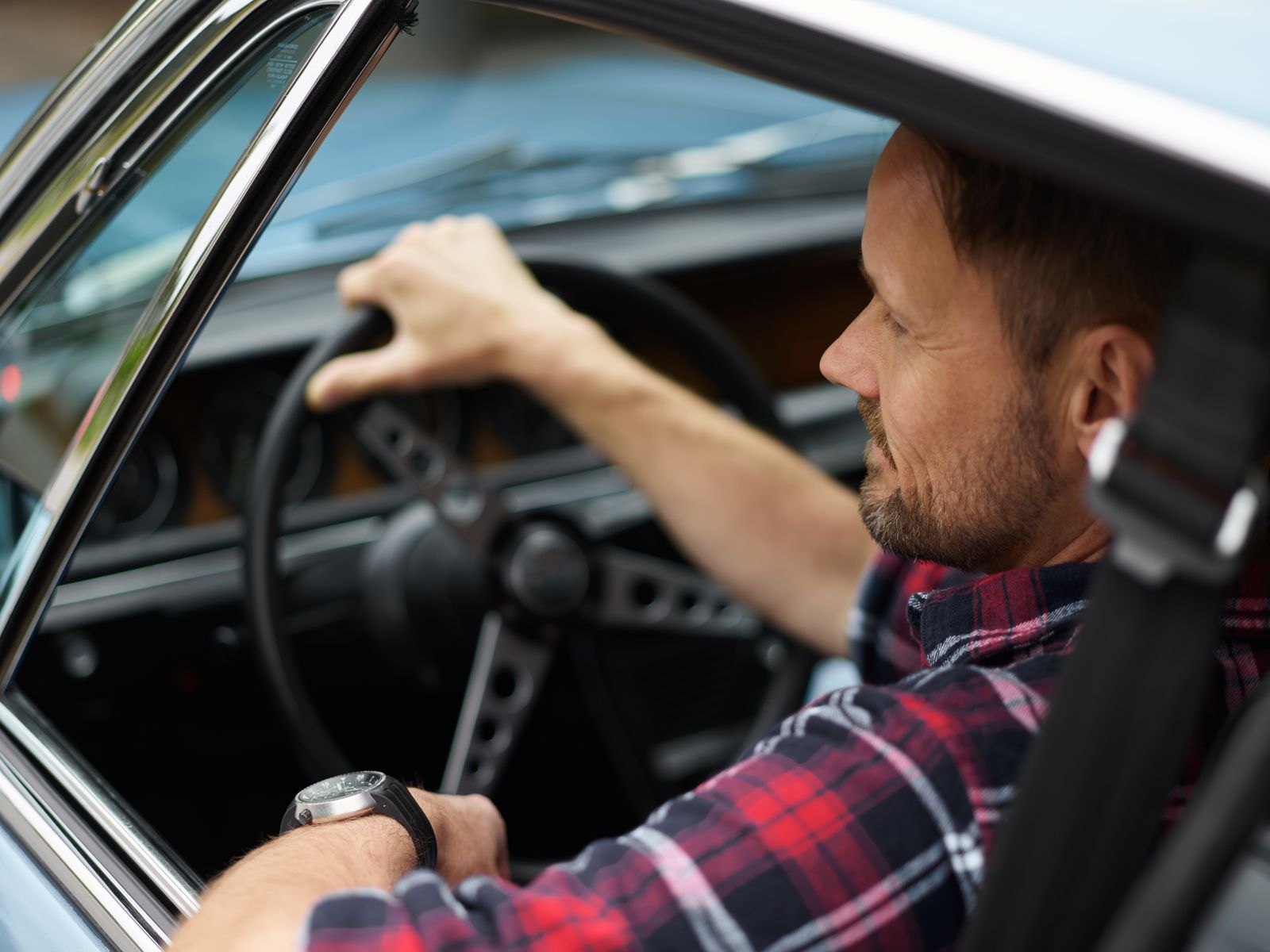 Conducteur au volant de sa voiture en lumière naturelle